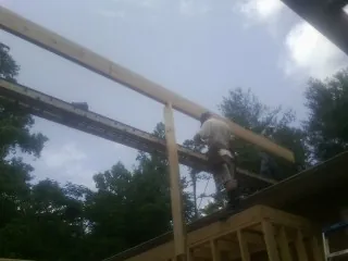 Carpenter setting a ridge beam over a new addition frame — Ice Dam Removal by Roofing Brothers in Perrysville