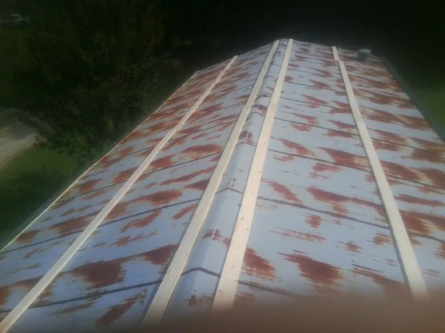 Rusted metal roof panels with new wood purlins before replacement — Storm Damage Roof Repair in Perrysville by Roofing Brothers