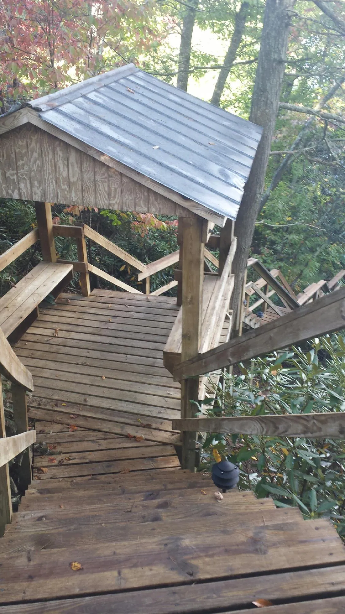 Metal roofed shelter over wooden steps on a wooded walkway — Skylight Repair & Installation work by our crew in Perrysville