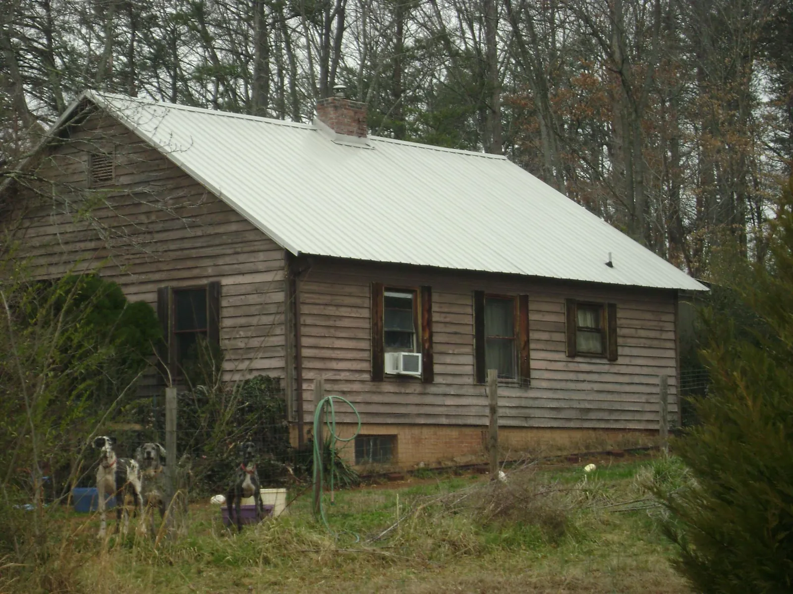 White metal roof on an old wood sided farmhouse, from a Metal Roof Installation job in Perrysville